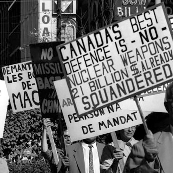Des citoyens manifestent contre lachat et larmement nucléaire des
missiles Bomarc. Ils tiennent des affiches qui disent, en anglais : « La
meilleure défense du Canada nest PAS une arme nucléaire », « OUI à
linterdiction des essais, NON aux bases nucléaires » et « Pas de bases
de missiles au Canada. »
