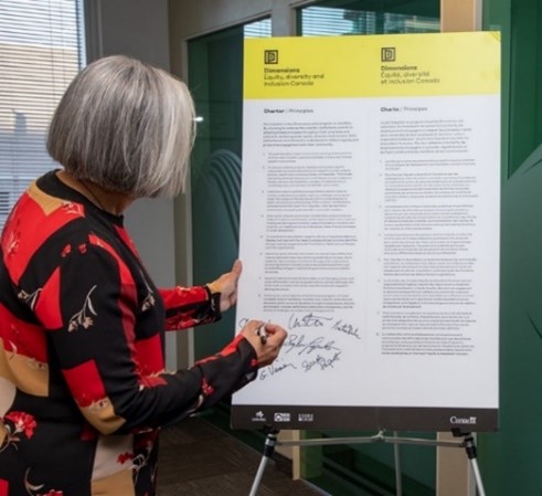 President Rumina Velshi signing the Dimensions EDI Charter.