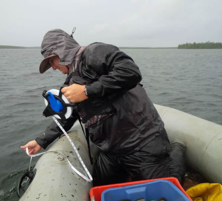 CNSC staff measuring depths for fish nets near McClean Lake