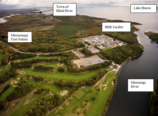 Photographie aérienne qui montre l’emplacement de la raffinerie par rapport à la ville de Blind River, à la Première Nation de Mississauga, au lac Huron et à la rivière Mississagi. Tous les emplacements sont indiqués sur la photo avec des bulles de texte.