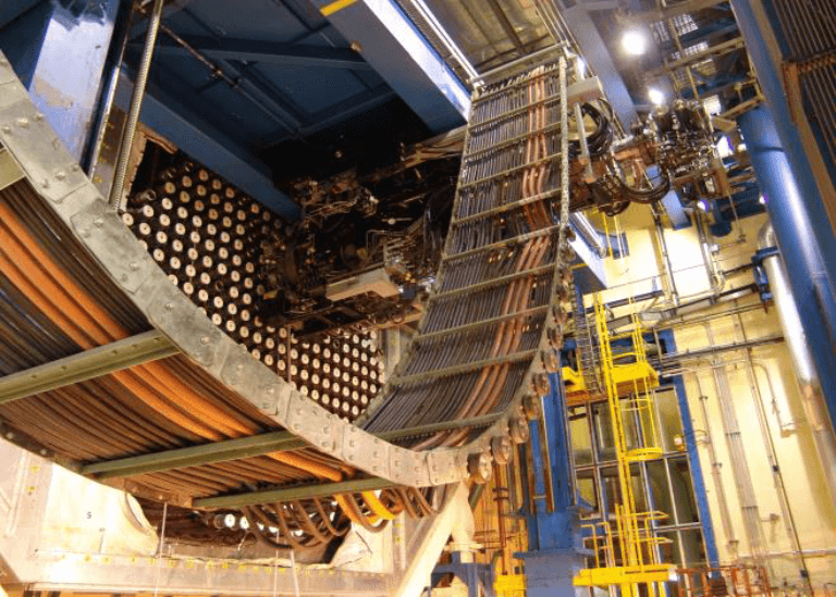 Text Box: À Gentilly-2, une machine à chargement de combustible est utilisée pour retirer le combustible du cœur et vidanger l'eau lourde des tubes de force (Photo gracieuseté d'Hydro-Québec).
