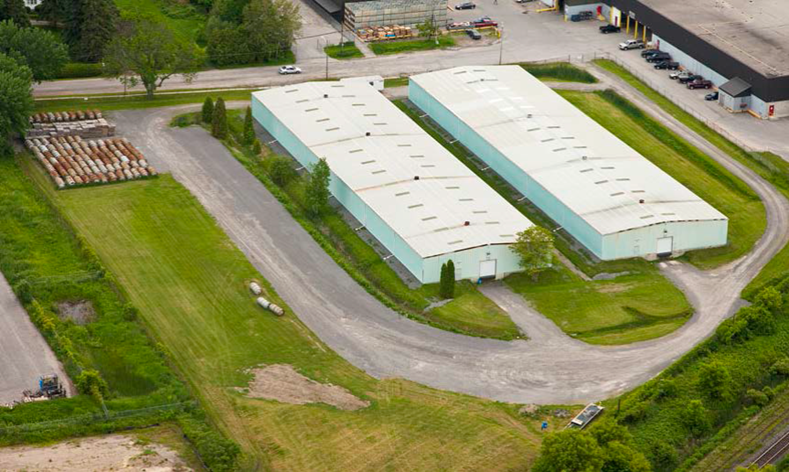 Cette photo montre une vue aérienne de l’emplacement du site 2 de l’Installation de conversion de Port Hope. Ce site se compose de bâtiments de stockage.
