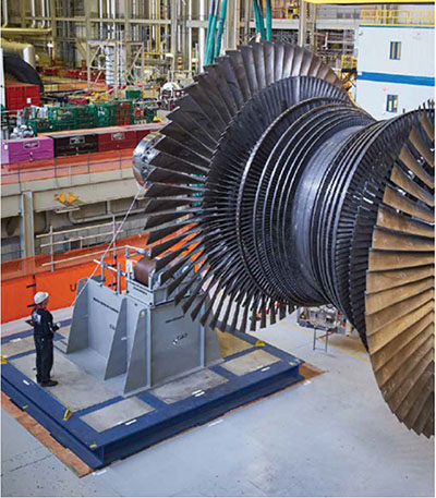 A turbine spindle being lifted into place in the refurbishment of Unit 2 at the Darlington Nuclear Generating Station as an Ontario Power Generation (OPG) employee oversees its placement.
