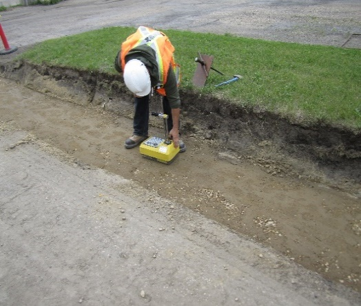 Travailleur utilisant une jauge portative pour mesurer les caractéristiques du sol