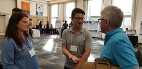 Two CNSC employees engaged in a conversation with a member of the public at one of the CNSCâ€™s Meet the Regulator events in Ottawa in June 2018.