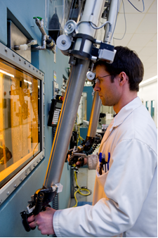 This picture shows a Nordion employee working with a hot cell manipulator