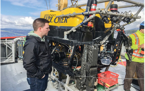 Image of Dr. Jeff Binns, corrosion scientist at the NWMO, examining the robot used in underwater research for the effects of deep water pressure on barrier materials, conducted in partnership with Ocean Networks Canada at the University of Victoria