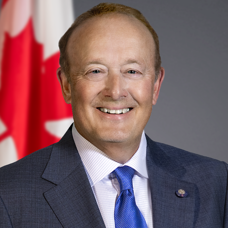 Official portrait of Pierre Tremblay, with the Canadian flag in the background.
