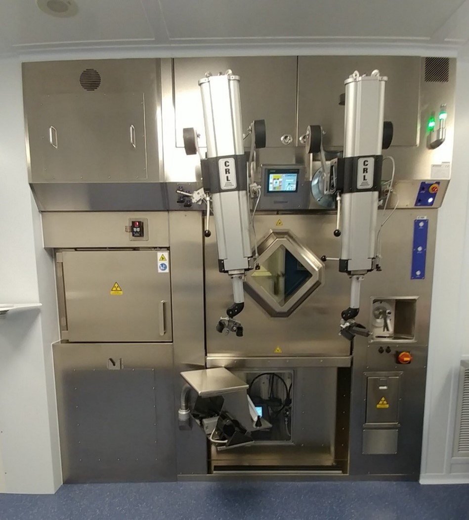 Photo displays an example of a hot cell with manipulators. The hot cell shown has 7.5 cm lead shielding in the walls, floor and ceiling. The lead glass window is 18 cm thick.