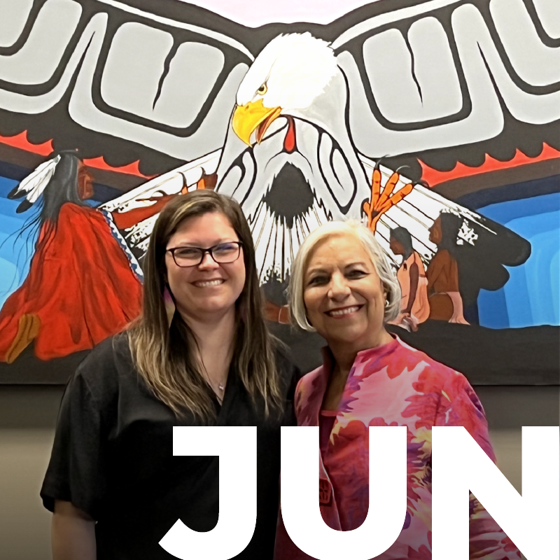 President Velshi and Chief Emily Whetung stand behind the word June