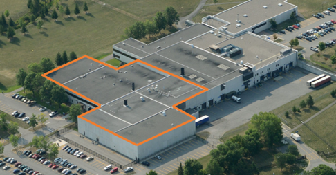 Photographie aérienne qui montre l’installation en surbrillance orange. L’installation et l’espace vert qui l’entoure sont situés dans une zone industrielle de Kanata.